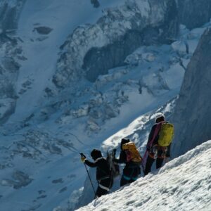 Mountaineers climbing a snow-covered slope at altitude